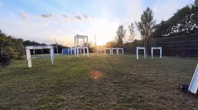 Závodní dráha pro FPV drony s průletovými brankami na travnatém hřišti
