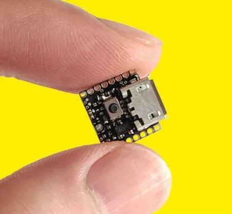 Drobná vývojová deska ATTO Arduino držená mezi prsty