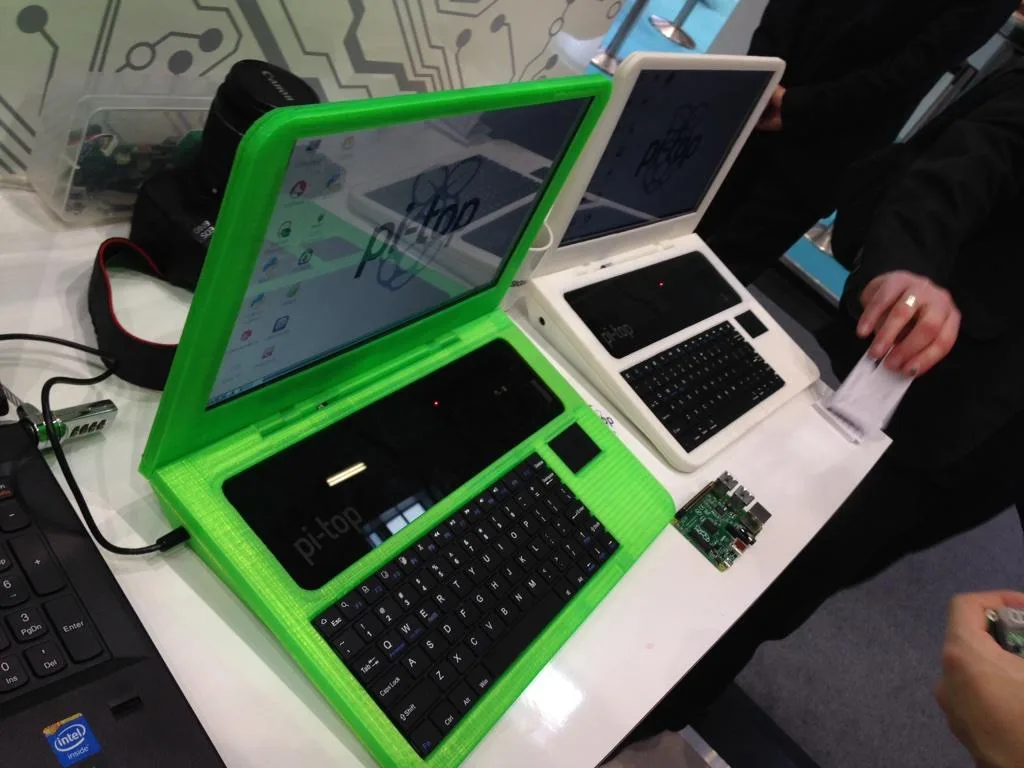 Zelený a bílý notebook pi-top s otevřenými displeji a klávesnicemi