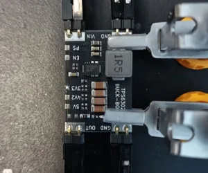 Detail měniče buck-boost s čipem TPS63020 a připojenými měřicími sondami