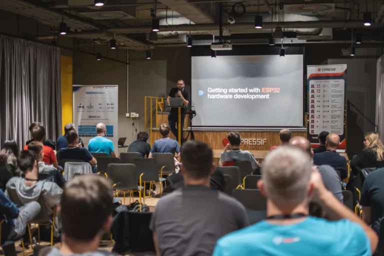 Přednášející na ESP community meetingu ukazuje prezentaci o vývoji hardwaru pro ESP32