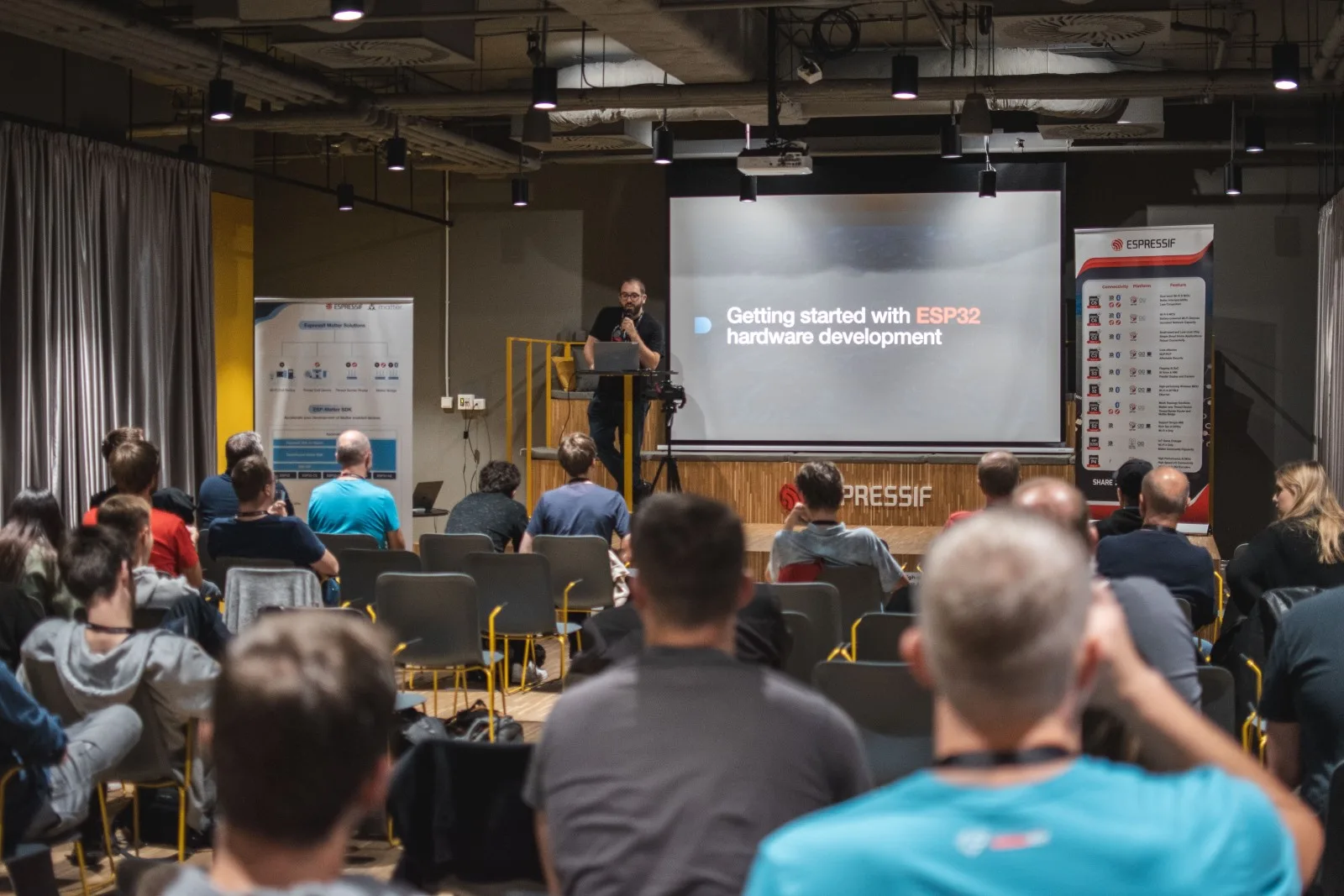 Přednášející na ESP community meetingu ukazuje prezentaci o vývoji hardwaru s ESP32