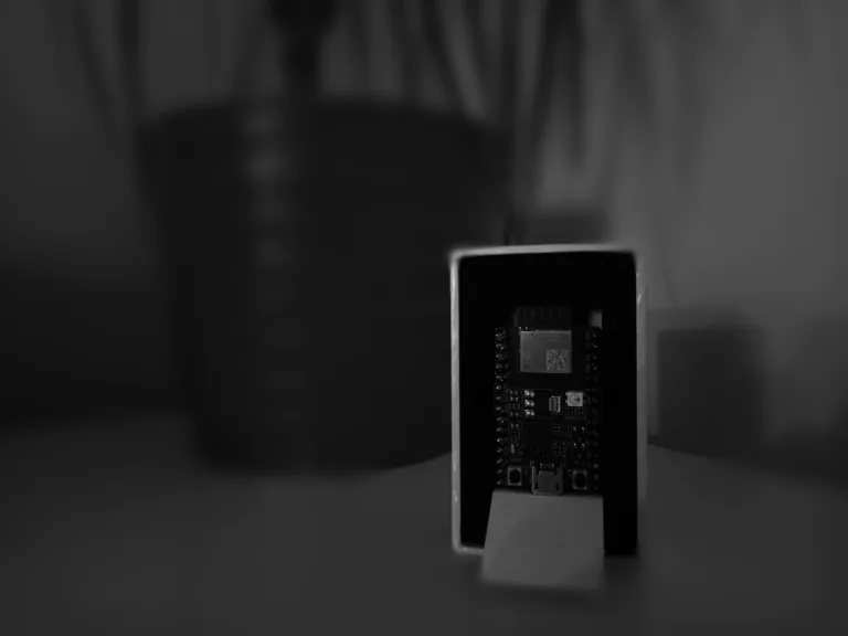 Vývojový kit ESP32-C3-DevKitM-1 stojící na tmavém podkladu