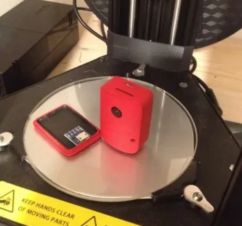 Červená 3D tištěná krabička pro ESP32-CAM a deska na tiskové podložce