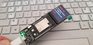 Vývojová deska ESP32-S2 připojená k USB kabelu na klávesnici