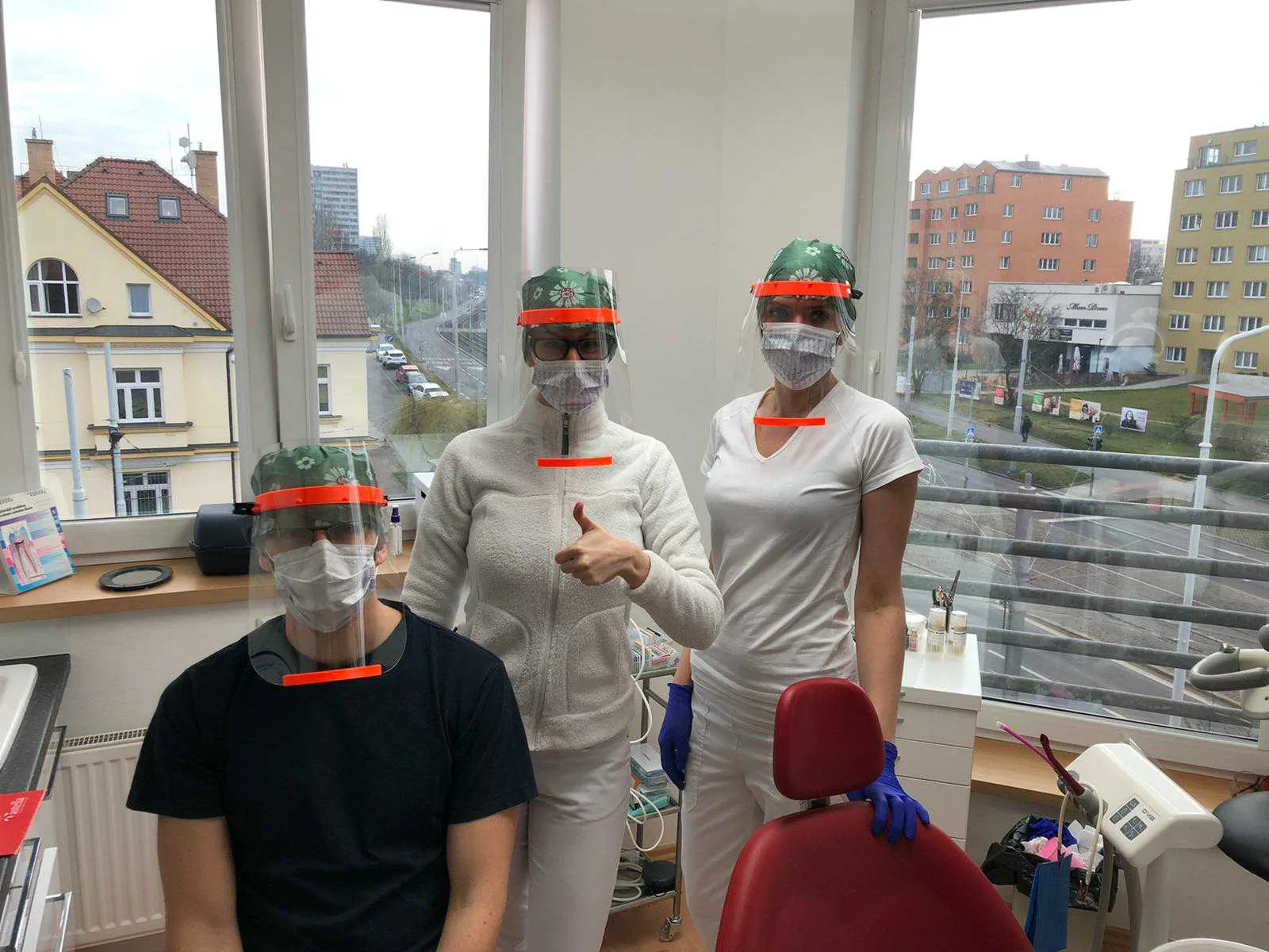 Tři lidé v ochranných štítech vytištěných na 3D tiskárně