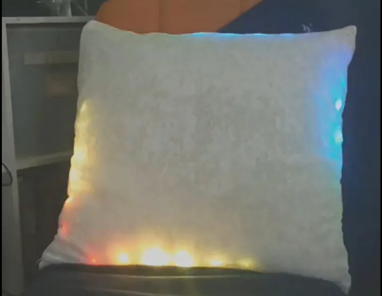 Bílý polštář s barevnými LED světly po okrajích