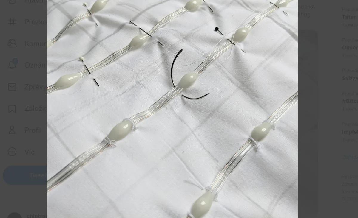 Detail LED pásků všitých do bílé látky polštáře