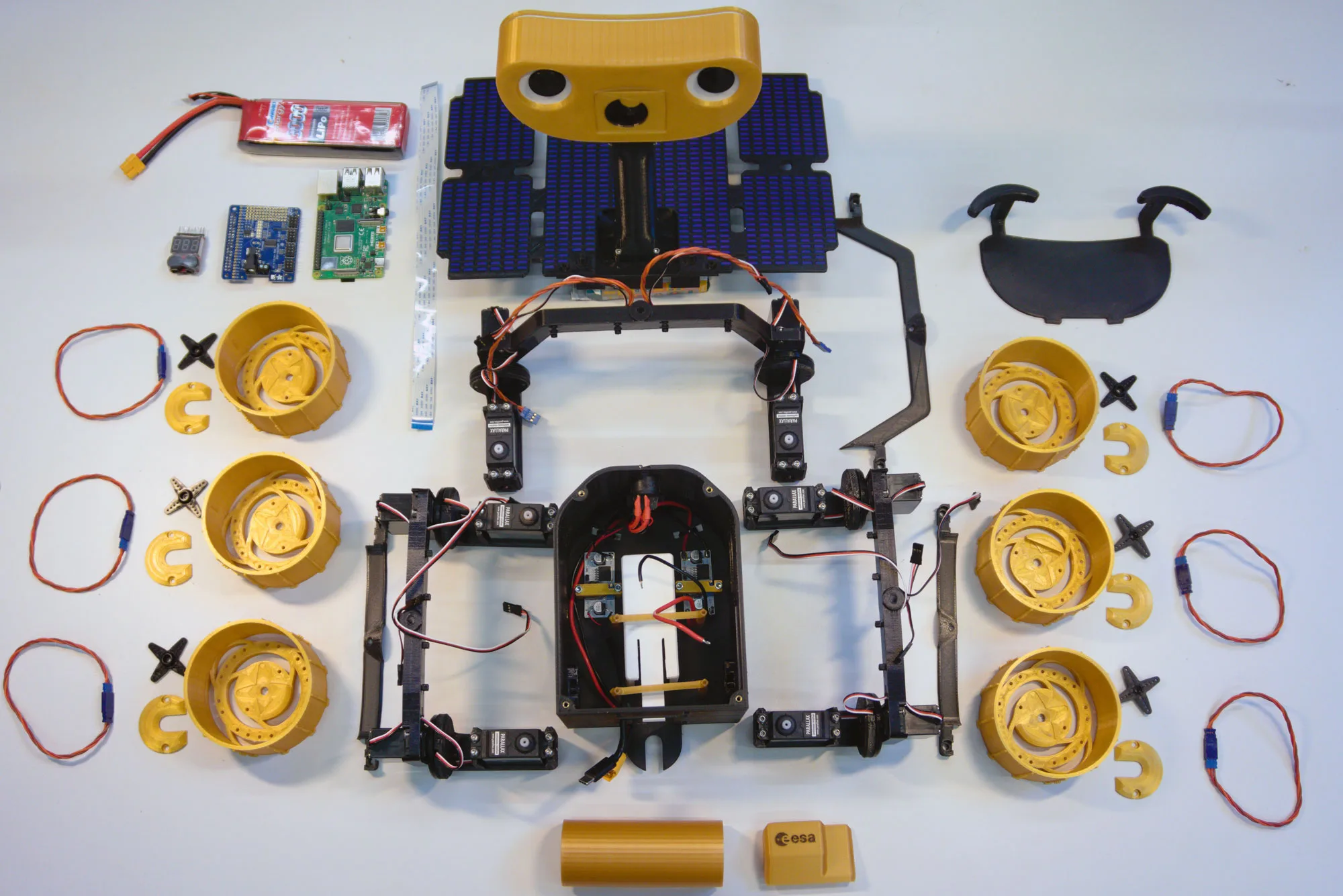 Rozložené díly 3D tištěného roveru ExoMy s Raspberry Pi a solárními panely