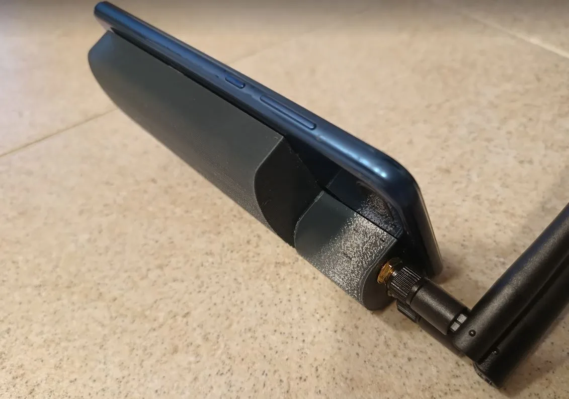 Telefon s 3D tištěným držákem a připojeným modulem pro Meshtastic