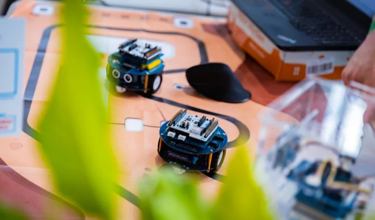 Koláž malých elektronických vývojových desek a zařízení na barevném pozadí