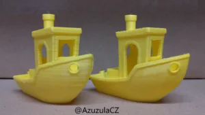 Dva žluté 3D výtisky lodiček Benchy pro porovnání kvality tisku