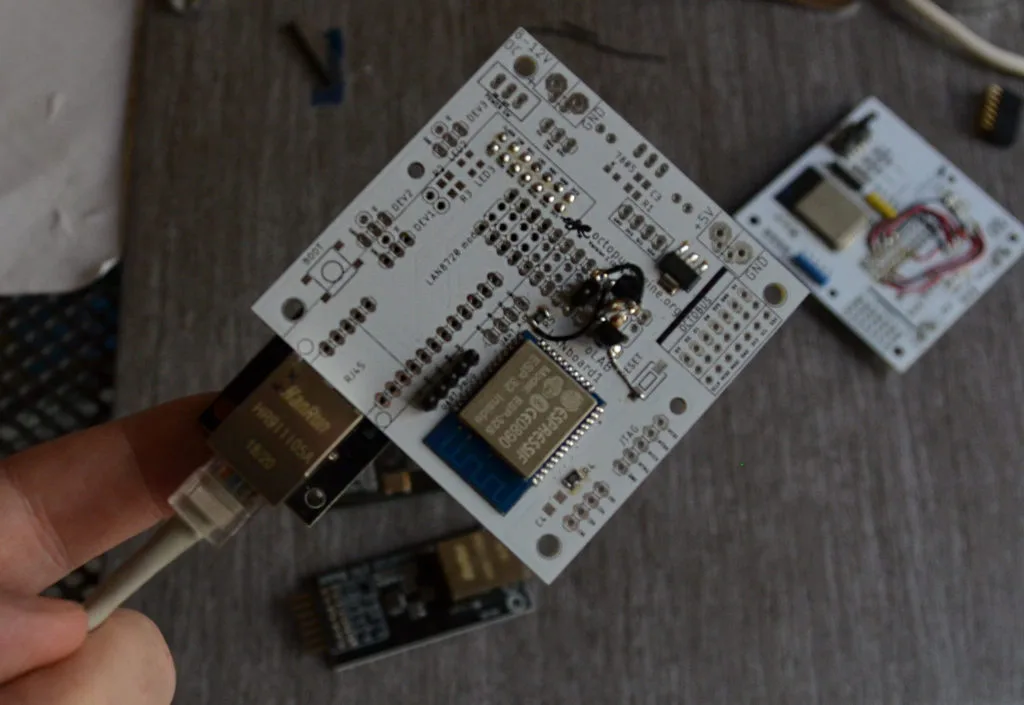 Vývojová deska OctopusLab s ESP32 a rozšiřujícími konektory držená nad stolem