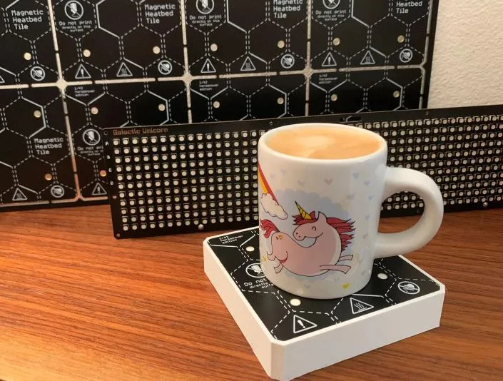 Hrnek s kávou stojí na vyhřívané podložce z 3D tiskárny Prusa XL