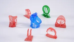 Barevné 3D tištěné testovací modely rozmístěné na podložce