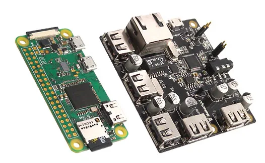 Zelená deska Raspberry Pi Zero vedle černé dokovací stanice s USB porty