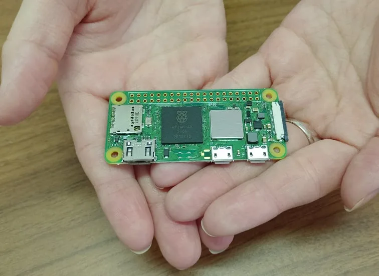 Raspberry Pi Zero 2 W držené v dlani, pohled na osazenou desku