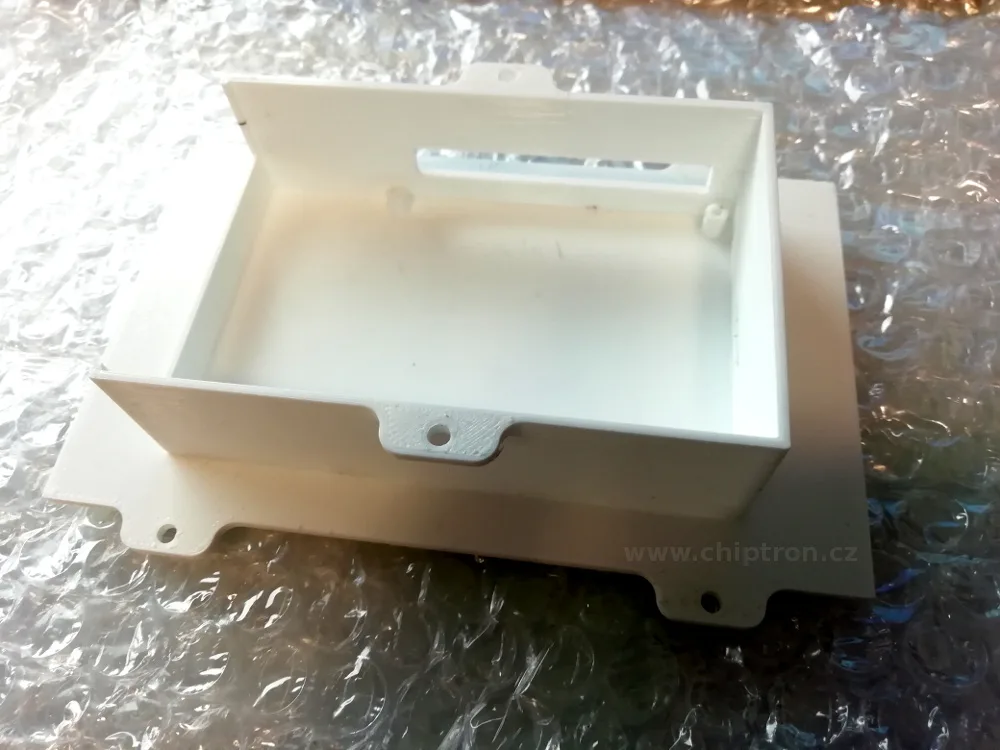 Bílý 3D tištěný kryt s vnitřním prostorem a montážními otvory