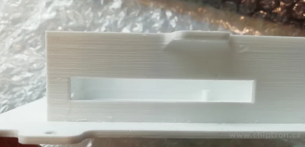 Šedý 3D tištěný kryt s obdélníkovým otvorem na přední straně