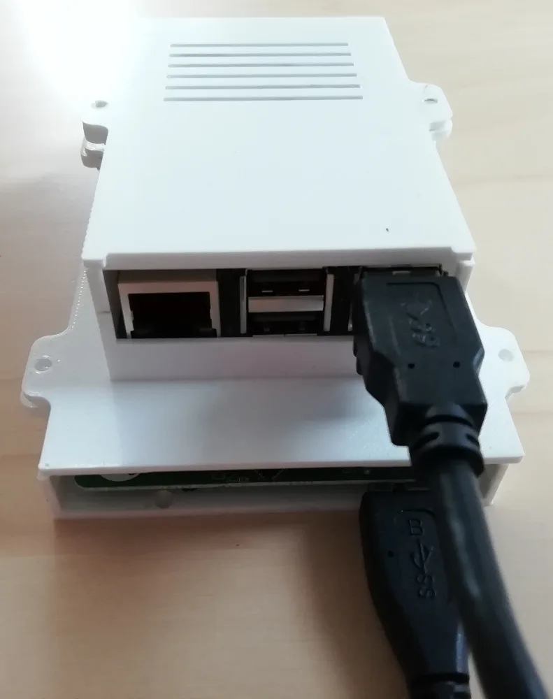Bílá 3D tištěná krabička pro Raspberry Pi s připojeným USB kabelem
