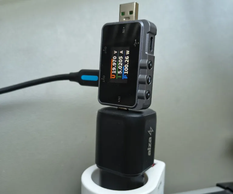 Měřák výkonu ukazuje 100 W odebíraných z adaptéru AlzaPower Ultimate X570