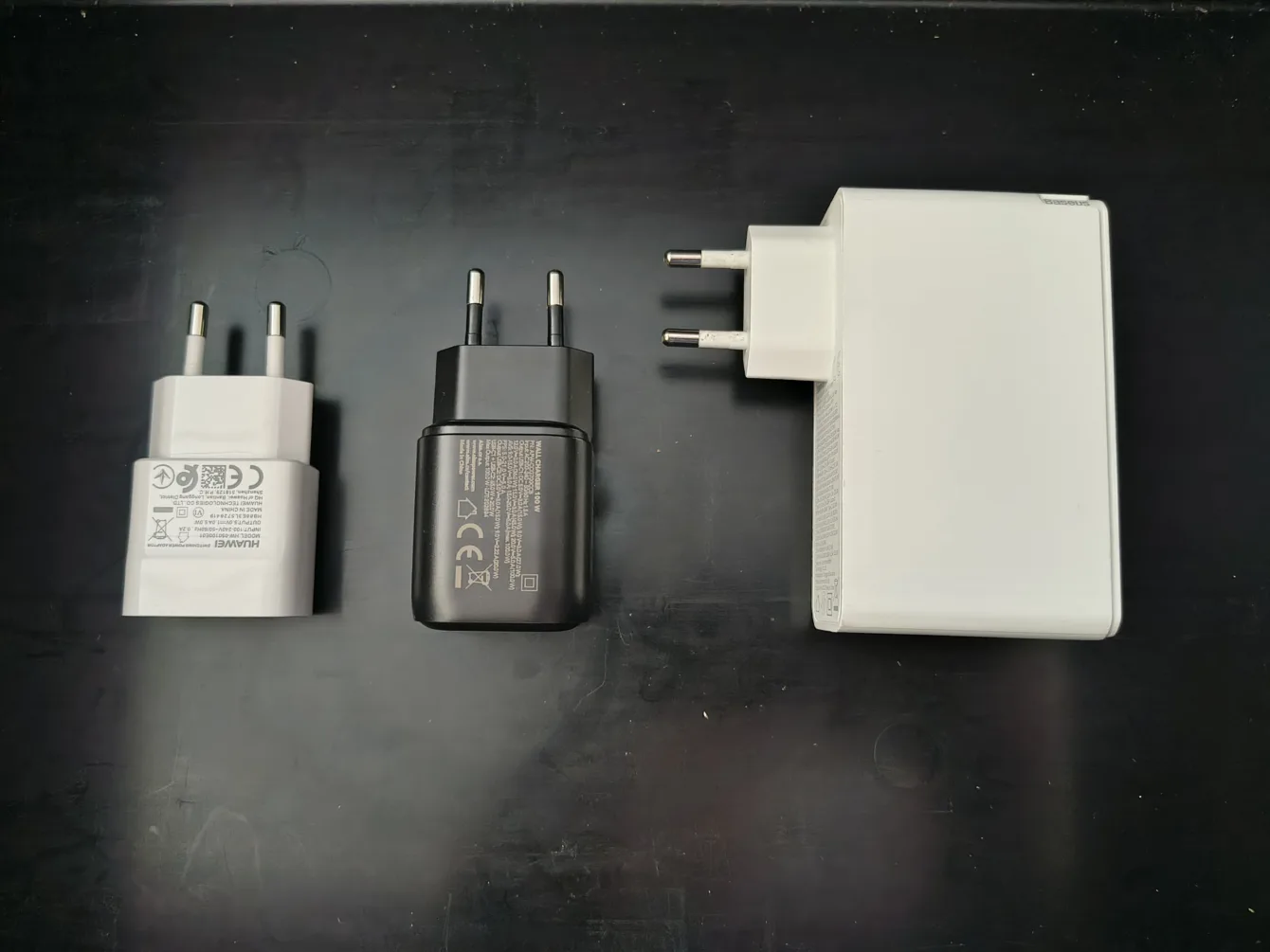 Porovnání adaptérů, zleva: 5V/1A, testovaný 100W AlzaPower Ultimate X570, 100 Baseus